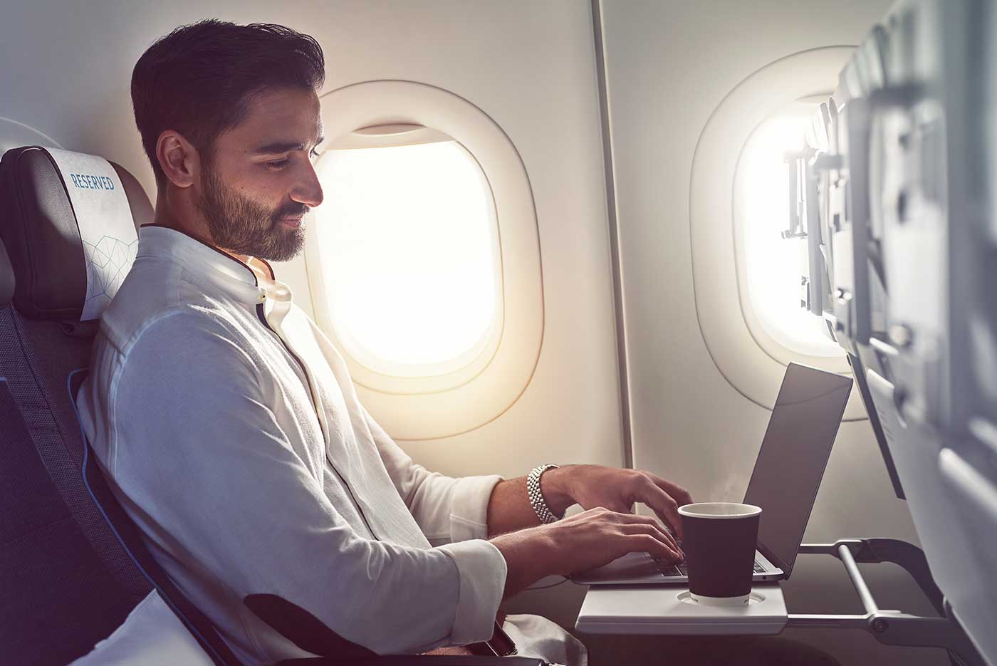 male-in-economy-with-laptop